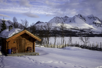 Wooden hut, snow mountains norway tromsö lake frozen over
