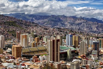 Urban landscape of La Paz with skyscrapers, a stadium and mountains in the background, The houses