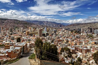 Panoramic view over La Paz with skyscrapers in front of a mountain landscape under a blue sky, The