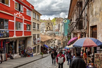Busy street with colourful buildings and umbrellas in an urban environment, people in the streets