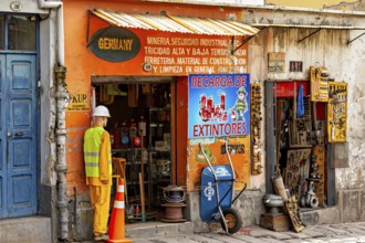A small shop with an orange façade and various tools in an urban street scene, A small DIY store in