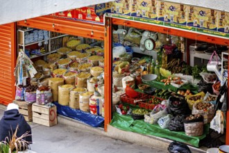 Lush market stall with different types of grain and traditional foods, small shops and restaurants