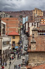 Lively city scene with tiled roofs and people on a street promenade, people in the streets of La