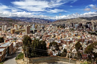 Panoramic view of a city with hills and many clouds in the sky, The houses and skyscrapers of the