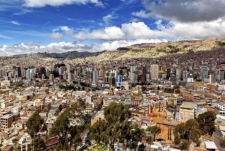 Cityscape with skyscrapers and cloudy sky in a mountain environment, The houses and skyscrapers of