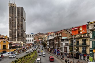 Busy urban street with skyscrapers and billboards, surrounded by mountains and cloudy skies, The