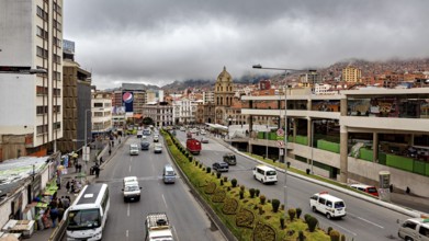 Urban scene with a wide street, traffic, a church and clouds over the mountains, The main streets