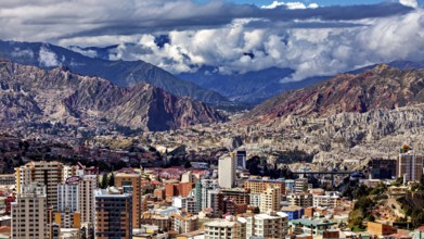Panorama of a city surrounded by mountains and under a cloud cover, The houses and skyscrapers of