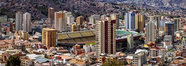 Urban scenery with stadium and skyscrapers in front of mountains, The houses and skyscrapers of the