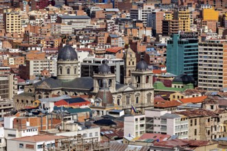 A cathedral surrounded by urban development, The houses and skyscrapers of the city centre of La