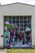 Garage door decorated with colourful graffiti and abstract shapes, at the port of Linz Upper