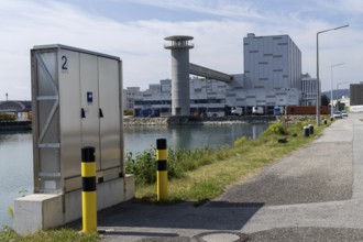 Industrial scenery with buildings next to a street under a blue sky, at the harbour Linz Upper