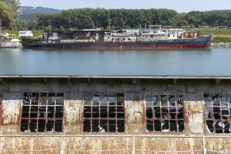Industrial landscape with abandoned plant and ships in the background, at the harbour of Linz Upper