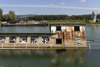 Rusty, dilapidated building on the water in a natural environment, at the harbour Linz Upper