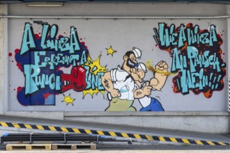 Colourful comic-style graffiti with fighting characters and lettering, at the port of Linz Upper