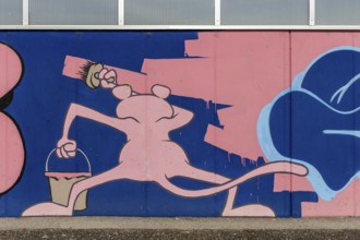 Lively cartoon mural with figure and bucket in pink tones, at Linz harbour Upper Austria Austria