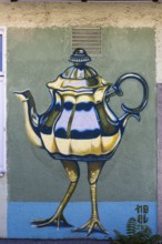 Surreal depiction of a teapot with legs, as a coloured mural, at the port of Linz Upper Austria
