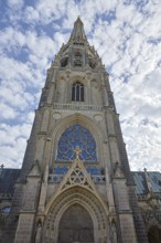 Gothic church façade with detailed stained glass windows and cloudy sky, Maria Empfängnis Dom Linz
