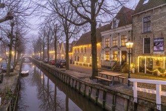 Typical canal in the foggy evening twilight, Harlingen, Friesland, Netherlands