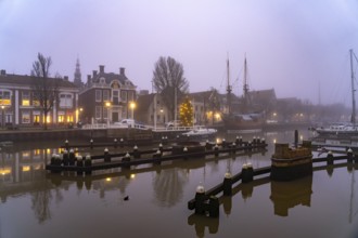 Typical canal in the foggy evening twilight, Harlingen, Friesland, Netherlands