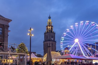Ferris wheel on the Grote Markt at Christmas time and the Martinitoren or Martini tower of the