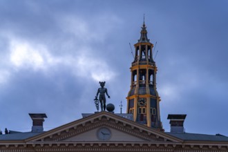 Statue of the god Mercury on the roof of the Korenbeurs former grain exchange and the steeple of