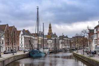 Typical canal with sailing boats and the tower of the Aa church in Groningen, Netherlands