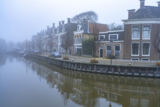 Typical canal in the winter fog, Harlingen, Friesland, Netherlands