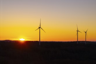 Three wind turbines in front of an orange-coloured sunset, near Schorndorf im Remstal,
