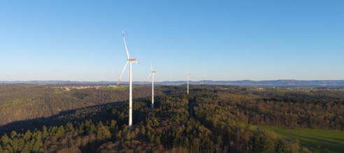 Wind turbines on a wooded hill under a clear blue sky, near Schorndorf im Remstal,