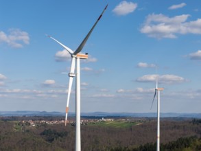Close-up of wind turbines with a village in the background, maintenance work, repair, near