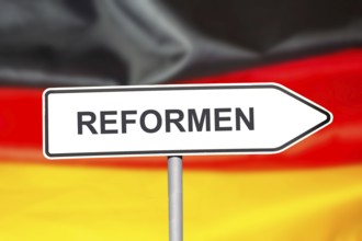 (Photomontage) Directional arrow with the inscription REFORMEN in front of a German flag