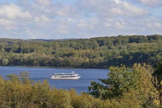 View of the Möhnesee with the passenger ship MS Möhnesee, autumn atmosphere, blue cloudy sky,