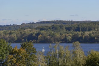 View of the Möhnesee with sailing boat and the Möhnesee tower, autumn atmosphere, blue sky,