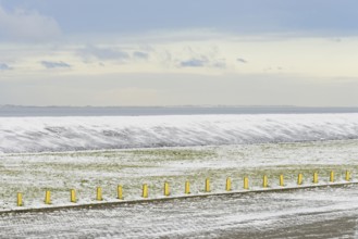 North Sea coast on a winter's day, snow-covered dyke and boundary posts, North Sea, Norddeich,