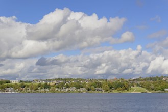 View over the Möhnesee, Körbecke village with the lake park and the lakeside promenade, blue cloudy