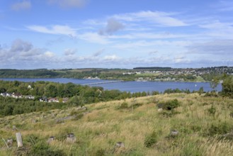 View over the Möhnesee, Körbecke village with the lake park and the lakeside promenade, blue cloudy