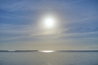Sunbeams illuminate the calm ocean surface under a clear sky, Flamingo, Everglades National Park,