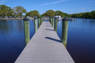 Wooden walkway leads over calm water to a boat dock, Flamingo, Marina, Everglades National Park,