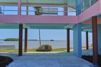 Pastel-coloured building with a view of the sea and a small island, National Park Info Center,
