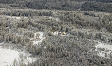 Aerial view of the Meschede forest near Enste with a country house in Meschede in winter with snow