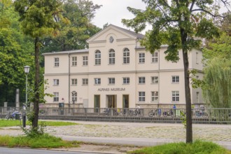 Front view of the Alpine Museum, framed by trees. A classic building in an urban environment,