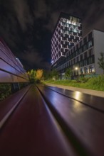 Night scene with modern buildings and unique lighting, urban atmosphere, Munich, Germany