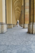 Long corridor with arches and columns, stone floor in a quiet atmosphere, Munich, Germany