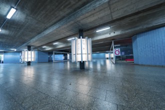 Empty underground station with blue walls and concrete, modern atmosphere, Munich, Germany