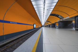 Futuristically designed underground station with bright orange walls and clear lines, Munich,