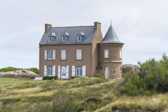 House and granite boulders around Perros-Guirec at the Pink Granite Coast in Brittany, France