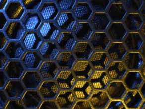Full frame colourful illuminated detail of a metallic grid in front of a loudspeaker