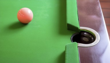AI generated image showing a billiards table closeup with ball and pocket