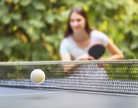 AI generated table tennis scenery including a ball, table with netting and female player